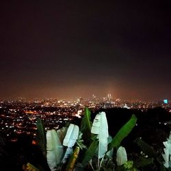 Illuminated city against sky at night
