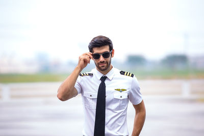 Portrait of young man wearing sunglasses standing outdoors