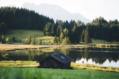 Scenic view of lake by trees against mountain