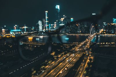 High angle view of illuminated street amidst buildings at night