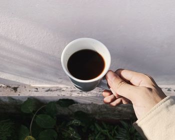 Midsection of person holding coffee cup