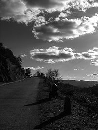 Empty road against cloudy sky