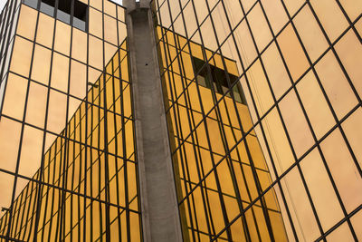 Low angle view of glass building against sky