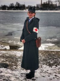 Portrait of army doctor standing against lake during winter