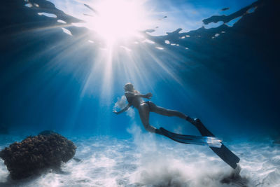 Rear view of woman swimming in sea