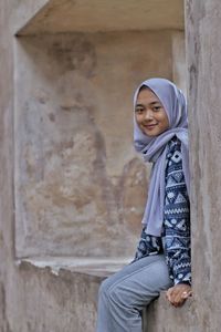 Portrait of smiling girl against wall