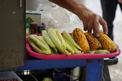 Cropped hand of person holding grilled corn