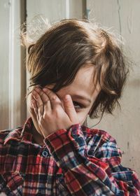 Close-up of a kid covering his face with his arm