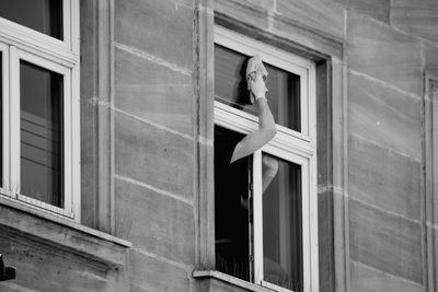 Low angle view of human arm on building