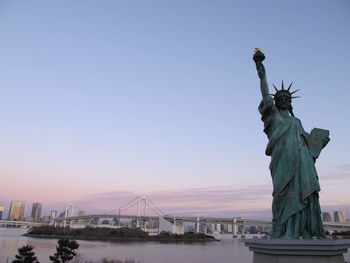 Statue in city against clear sky