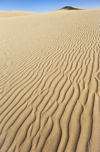 Sand dunes in desert against sky