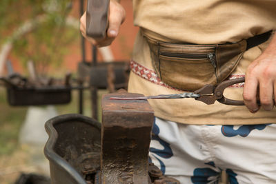 Midsection of man working at workshop