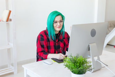 Portrait of young woman sitting on table