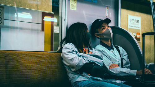 Full length of woman sitting at train