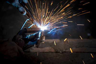 Welding of steel, sparking, not wearing gloves, light colored like fireworks.