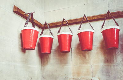 Low angle view of red buckets hanging on wall