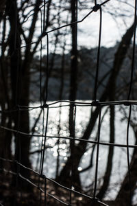 Low angle view of metal in cage against sky