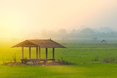 Gazebo on field against sky during sunset