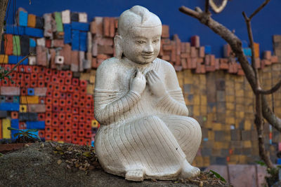 A white ceramic buddha statue in the garden of the tao hong tai ceramics factory in thailand