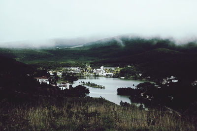 Scenic view of river by mountains against sky