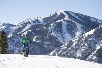 A woman riding her fat bike on a beautiful winter day in sun valley.