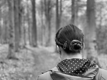 Black and white monochrome rear view of woman walking in woodlands