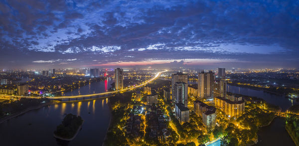 High angle view of illuminated buildings against sky at night