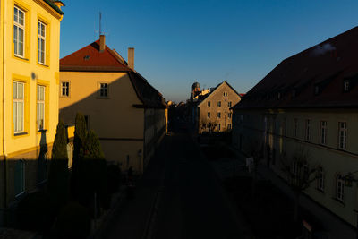 Street amidst buildings against sky at dusk