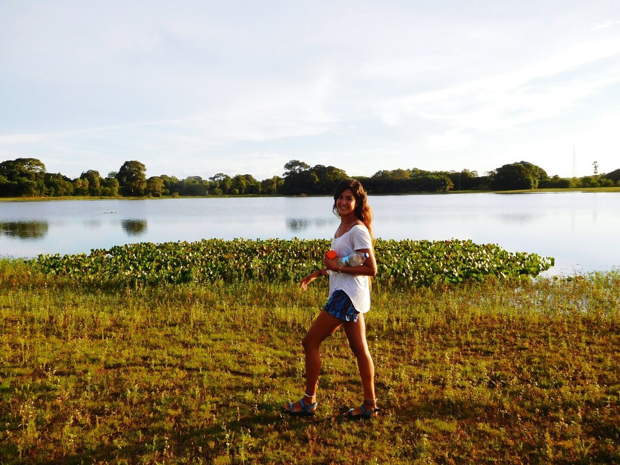 FULL LENGTH OF BOY STANDING IN LAKE AGAINST SKY