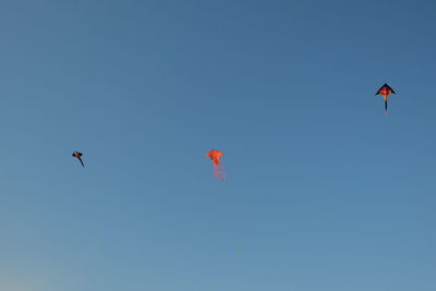 Low angle view of kite flying against clear blue sky