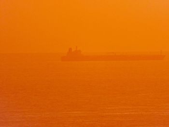 Scenic view of sea against orange sky