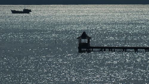 Silhouette man in sea against sky