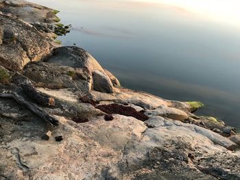 Rock formation in water against sky