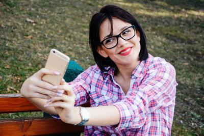 Portrait of smiling woman holding smart phone