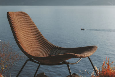 Close-up of empty chair on sea shore