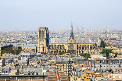 Aerial view of buildings in city against sky