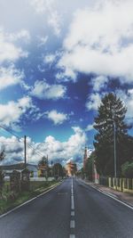 Road by trees against sky