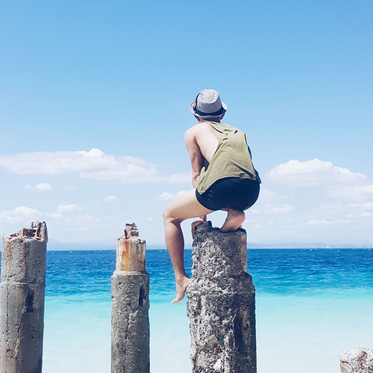 sea, horizon over water, sky, water, standing, blue, rear view, lifestyles, leisure activity, casual clothing, tranquility, nature, sunlight, beauty in nature, tranquil scene, three quarter length, scenics, day