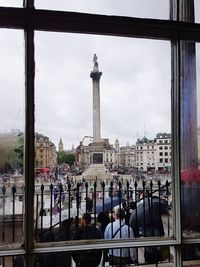 People in town square against sky in city