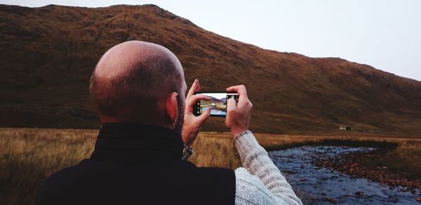 Rear view of man photographing