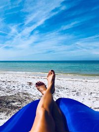 Low section of woman relaxing on beach