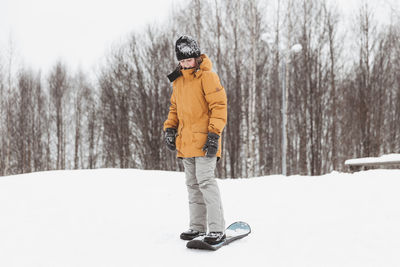 Cute teenage girl rides a snowskate in a winter park, healthy lifestyle