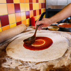 Close-up of man preparing pizza in kitchen at restaurant