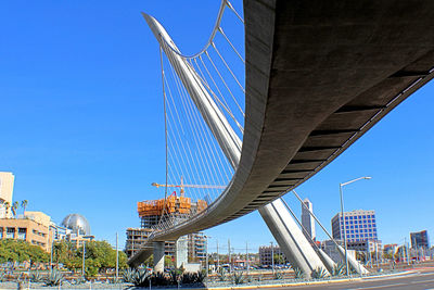 Ferris wheel in city against clear blue sky