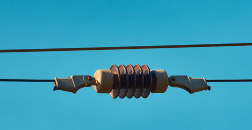 Close-up of telephone pole against blue sky