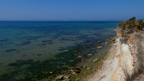 Scenic view of sea against clear blue sky