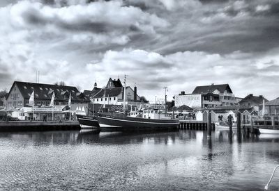 Boats moored in river against buildings in city