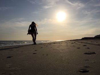 Silhouette of people on beach at sunset