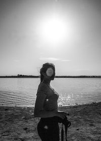 Woman standing at beach against clear sky