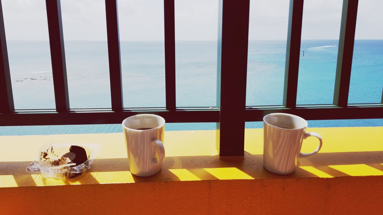 water, table, sea, food and drink, drink, day, nature, cup, no people, window, mug, refreshment, still life, sunlight, outdoors, glass - material, transparent, coffee cup, glass, crockery, tea cup